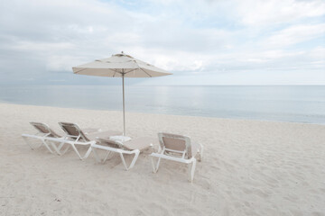 Beach chairs and umbrella on the beach on high key