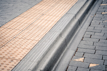 Yellow Braille blocks on public transport station for person with a physical disability