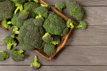 fresh broccoli on a wooden tray top view. background with fresh cabbage of broccoli.