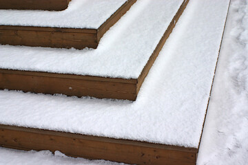 fresh snow on the steps of the wooden porch