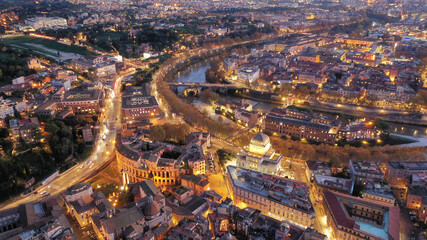 Aerial drone night shot of small illuminated Tiber Island with a number of historical monuments...