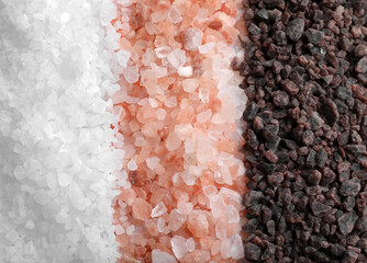 Different salts as background, closeup. Top view