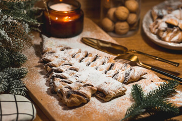 New Year's table. Treats for guests. Puff pastry cake with chocolate in the form of a Christmas tree on a wooden background. The concept of a family holiday. A copy of the space for the text.