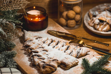 New Year's table. Treats for guests. Puff pastry cake with chocolate in the form of a Christmas tree on a wooden background. The concept of a family holiday. A copy of the space for the text.