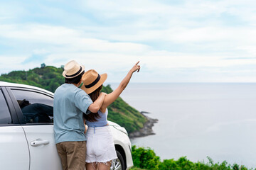 Young couple traveler looking at the beautiful sea view with their car while travel driving road...