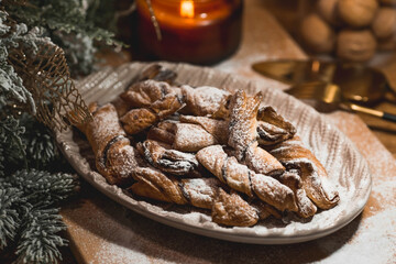 New Year's table. Treats for guests. Puff pastry cookies with chocolate in the form of bows on a wooden background. The concept of a family holiday. A copy of the space for the text.