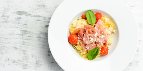 Pasta with prosciutto, blue cheese and tomatoes. Italian cuisine. Menu. Top view.