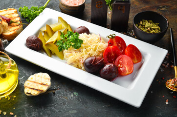 Marinated and pickled vegetables: tomatoes, cabbage, cucumbers and plums. Cold snacks. Top view.