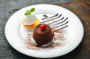Dessert. Traditional chocolate fondant with ice cream and chocolate on a plate. Top view.
