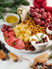 Soft focus, antipasti with cheese, sausage, nuts, cracker, honey, on a round marble tray, vertical,...