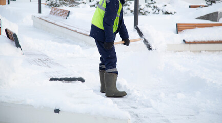 Snowfall.There is a lot of snow in the city.Snow removal by an employee of communal services.