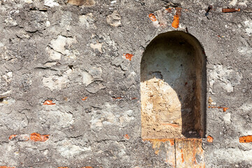 Antica nicchia sul muro storico in mattoni e pietra del monastero. Particolare architettonico del muro del monastero.