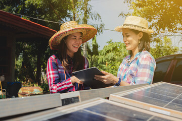 A farmer woman uses a tablet to monitor solar cells for managing solar electric power in...