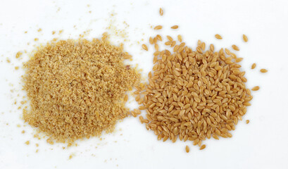 Whole and ground golden golden flax seeds. Two heaps are isolated on a white background.