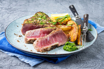 Traditional Japanese tuna tataki steak with hash browns and wasabi cream served as close-up on a Nordic design plate