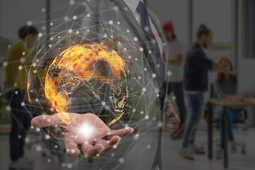 Double exposure of Businessman hand holding the particle earth with technology network circle over the photo blurred of Group of asian and diverse Business people working and brainstorming