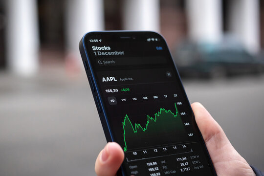 Kharkov, Ukraine - December 1, 2021: Apple AAPL stock trade close-up. Financial graphs, investment, digital banking concept. Smartphone with stock market app in hand