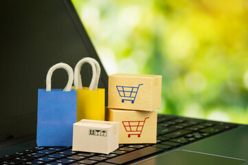 Online shopping or delivery service concept shopping bag with cardboard boxes on laptop keyboard...