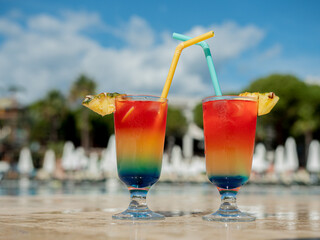close-up of summer cocktails with a straw by the pool. Summer vacation concept