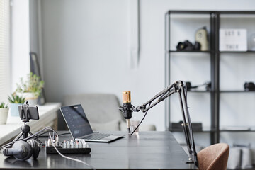 Side view background image of professional microphone in recording studio with laptop, copy space