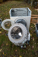 Pile of home bulky waste as wash machine prepared for pickup at the street in German city.