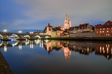 Obraz premium Steinerne Brücke und Donau Ufer mit Dom in der blauen Stunde beleuchtet mit Spiegelungen