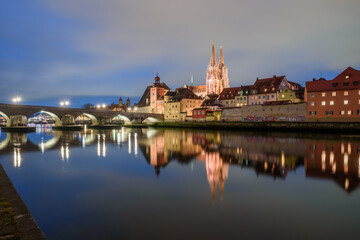 Fototapeta na wymiar Steinerne Brücke und Donau Ufer mit Dom in der blauen Stunde beleuchtet mit Spiegelungen