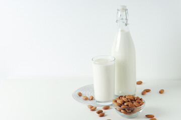 A glass with almond milk and the bowl with almonds	
