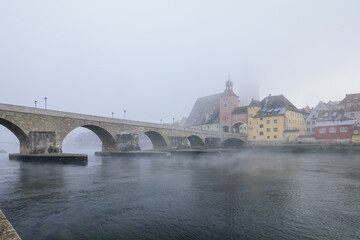 Fototapeta premium Steinerne Brücke Regensburg im Nebel im Winter 