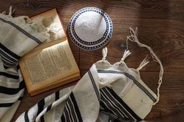 Jewish traditional prayer supplies. Talite, kippah, torah on a wooden table. Shabbatta, Bar Mitzvah, Yom kippur concept