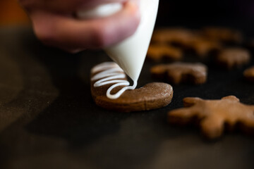 Icing a Gingerbread Candy Cane cookie