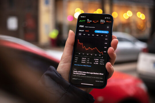 Kharkov, Ukraine - December 1, 2021: FedEx FDX stock trade. Financial graphs, investment, digital banking concept. Smartphone with stock market app in hand