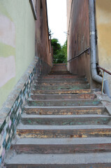 old narrow concrete staircase between the walls of buildings