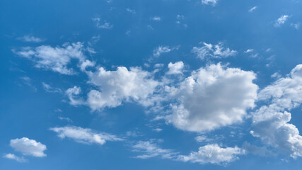 Wide view of white cumulus clouds in blue sky