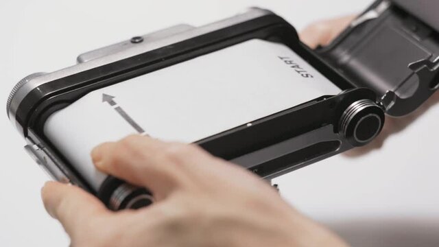 Loading film, User winding film on newly loaded medium format film camera ready to make photo