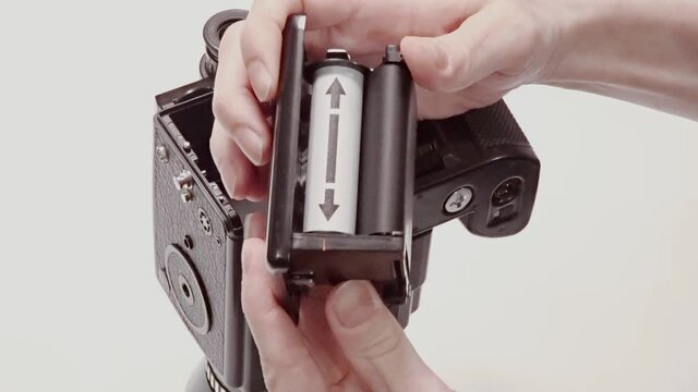 Loading film, User winding film on newly loaded medium format film camera ready to make photo