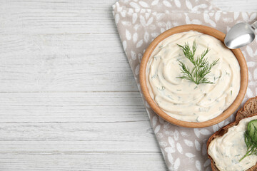 Tasty creamy dill sauce and sandwich on white wooden table, flat lay. Space for text