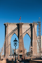 Fototapeta premium New York, USA - 2021: Brooklyn Bridge, built in 1883, was the first fixed crossing of the East River. Photo taken during the day with blue sky and view to the beautiful Manhattan.