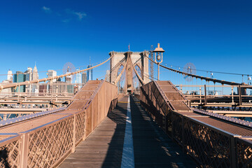 New York, USA - 2021: Brooklyn Bridge, built in 1883, was the first fixed crossing of the East River. Photo taken during the day with blue sky and view to the beautiful Manhattan.