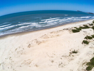Fototapeta na wymiar Beach with sand, waves and vegetation