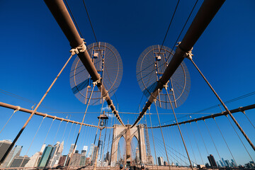 Obraz premium New York, USA - 2021: Brooklyn Bridge, built in 1883, was the first fixed crossing of the East River. Photo taken during the day with blue sky and view to the beautiful Manhattan.