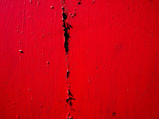  Scratched bright red paint surface in close-up.