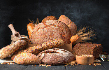 Assortment of rye and wheat bread on a dark background. Bakery products.