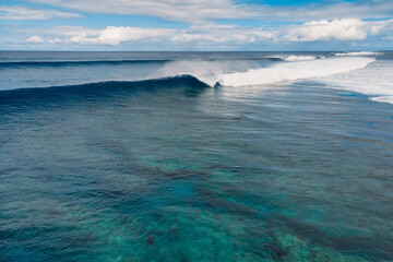 Blue waves in transparent ocean. Aerial view of surfing wave
