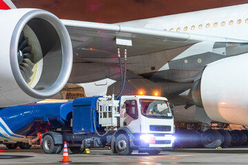 Truck with a tank of kerosene of aviation fuel connected to the fuel tanks of a large aircraft...