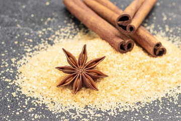 Star anise and cinnamon sticks on brown sugar.