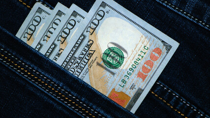 money, dollar bills in jeans pocket. US dollars are visible in your pocket. 100 dollar bills, out of pocket. Business exchange, seasonal discount concept. Wealth in pants. business and finance