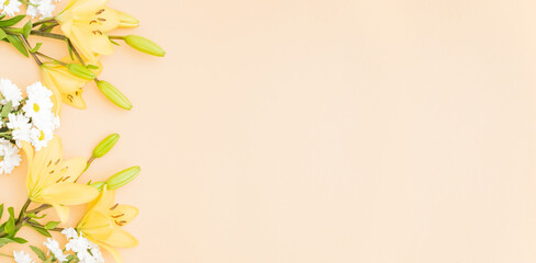 Flat lay frame with yellow lilies on color background