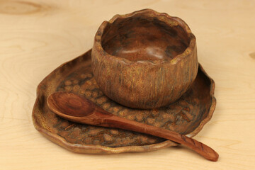 brown clay dishes on a wooden table. Soup plate, wooden spoon. Natural materials