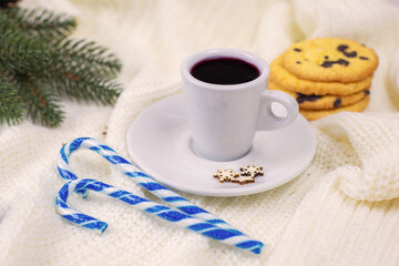 mug with tea in Christmas decorations on a white knitted blanket. New Year, the atmosphere of warmth, comfort and magic.